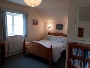 ein Schlafzimmer mit einem Bett, einem Fenster und einem Bücherregal in der Unterkunft Greystones Lodge in Swayfield