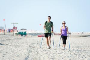 a man and a woman walking on the beach at Hotel Mediterraneo in Sottomarina