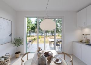 een keuken en eetkamer met een tafel en een lamp bij Västös Strand by FIRST Hotels in Lärbro