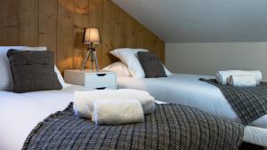 twee witte bedden in een kamer met een lamp op een tafel bij La Snaille des Planards in Chamonix-Mont-Blanc