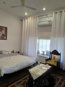 1 dormitorio con cama, mesa y ventana en Tranquility homestay, en Shivpurī