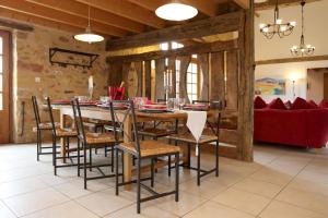a dining room with a large table and chairs at Lueurs de Gorce in Barjou