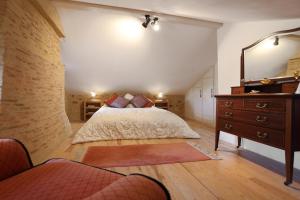 a bedroom with a bed and a dresser and a mirror at Lueurs de Gorce in Barjou +46 photos