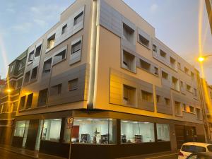 a building on a street with a car parked in front at Royal Flats in Las Palmas de Gran Canaria