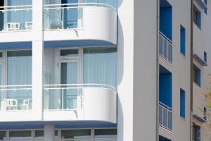 a white apartment building with a balcony at Hotel Mediterraneo in Sottomarina