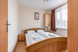 a bedroom with a bed and a window at Apartamenty przy Promenadzie by Renters in Świnoujście