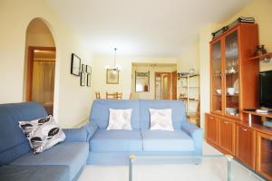 ein Wohnzimmer mit einem blauen Sofa und einem TV in der Unterkunft Apartment Cala de Nerja SpainSunRentals 1083 in Nerja