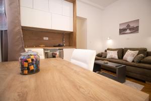 uma cozinha e sala de estar com uma mesa e um sofá em Frui Centro Zagreb em Zagreb