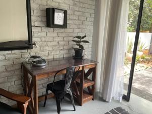- un bureau en bois avec un téléphone installé à côté d'un mur en briques dans l'établissement Blissful Stay, à Potchefstroom