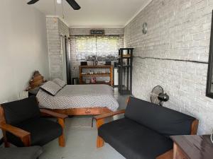 - une chambre avec un lit, deux chaises et un mur en briques dans l'établissement Blissful Stay, à Potchefstroom