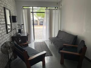 - un salon avec un canapé, des chaises et une fenêtre dans l'établissement Blissful Stay, à Potchefstroom