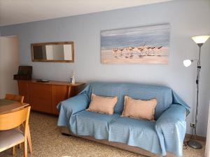 a living room with a blue couch and a table at Apartamento Laurel in Peniscola