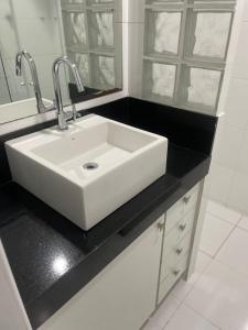 a bathroom with a white sink and a black counter at Copacabana Vista parcial do Mar, melhor ponto de Copacabana in Rio de Janeiro