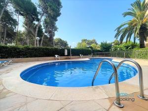 una gran piscina con 2 sillas alrededor en Paradis Sant Sebastian , climatizado y con piscina, en Salou