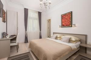 a white bedroom with a bed and a desk at Villa Sokol Apartments Opatija center in Opatija