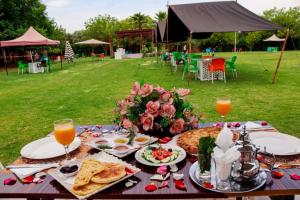 - une table de pique-nique avec de la nourriture et du jus d'orange dans l'établissement Tahnaout Multiservices, à Tahannaout