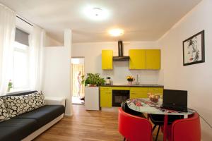 a kitchen and a living room with a table with a laptop at Apartments Top Center in Zagreb