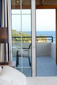 a bedroom with a bed and a view of the ocean at Thea Studios in Finikounta