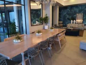 a dining room with a large wooden table and chairs at Luxury 264 The Blyde in Pretoria