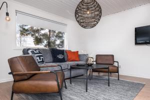 a living room with a couch and chairs and a table at Isaberg Golfklubb in Hestra