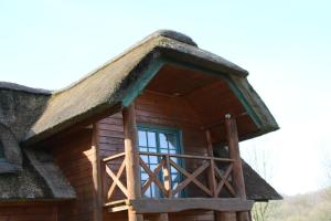 a log cabin with a thatched roof at Chaumière d'Albâtre -Gîte-Détente nature et bien être in Ourville-en-Caux