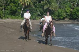 a man and a woman riding horses on the beach at Tapiru's House - Bahia Drake in Drake