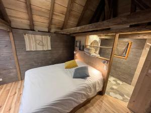 a bedroom with a bed in a wooden room at La maison de l'O in Saint-Laurent-des-Hommes