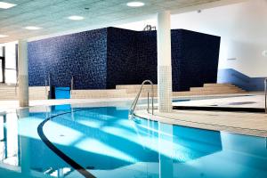 a swimming pool with blue water in a building at CPH Hotel in Copenhagen