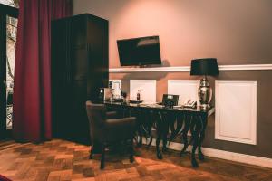 a room with a desk with a television and a chair at Hotel Villa Klemm - Wiesbaden City in Wiesbaden