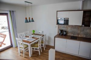 uma cozinha e sala de jantar com mesa e cadeiras em Przytulny Domek Marthy em Milówka