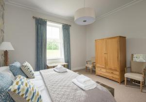 Un dormitorio con una cama grande y una ventana en The Beach House en North Berwick