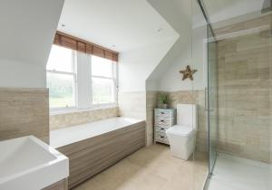a bathroom with a tub and a toilet and a shower at The Beach House in North Berwick