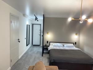 1 dormitorio con 2 camas y sofá en Lux apartment on Astana 12/1, en Öskemen