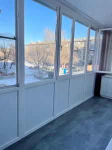 an empty room with windows in a building at Lux apartment on Astana 12/1 in Ustʼ-Kamenogorsk