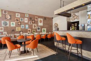 um restaurante com cadeiras laranja e um bar em Boa Hotel - BW Signature Collection - Lille Centre Gares em Lille