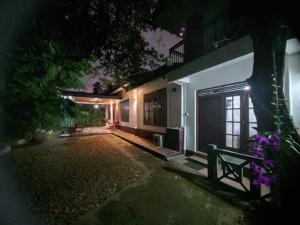 a house at night with a bench in front of it at Derick's Inn in Galle
