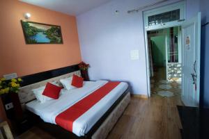 a hotel room with a bed with red pillows at Riva palace Homestay Rewalsar Lake in Malther