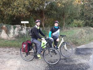 Due persone in bicicletta su una strada sterrata di Manoir du Bois Joly - Roulotte Vintage a Margon
