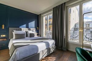 1 dormitorio con cama grande y ventana grande en Maison Barbès, en París