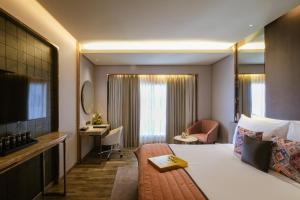 una camera d'albergo con letto e scrivania di The Park Indore a Indore