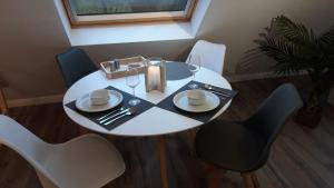 una mesa blanca con 2 sillas y una mesa con gafas en Ferienwohnung an der Kurklinik, en Bad Driburg