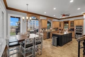 a kitchen with wooden cabinets and a table and chairs at Luxury 5 Acre Private Estate on Lake Ray Roberts in Sanger
