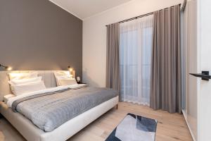 Un dormitorio con una cama grande y una ventana grande. en DasHaus 2 bedroom Apartment, en Tallin