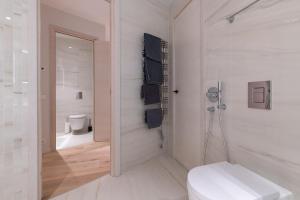 Un baño blanco con inodoro y espejo. en DasHaus 2 bedroom Apartment, en Tallin 58 fotos más