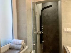 un bagno con doccia con porta in vetro di GOODMOOD Apartment a Debrecen