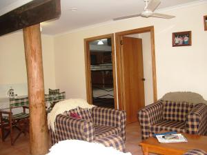 een woonkamer met 2 stoelen en een plafondventilator bij Atherton Blue Gum B&B in Atherton