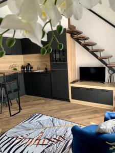 un soggiorno con scala e cucina di GOODMOOD Apartment a Debrecen Altre 22 foto