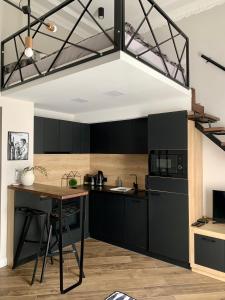 una cucina con armadi neri e tavolo in legno di GOODMOOD Apartment a Debrecen