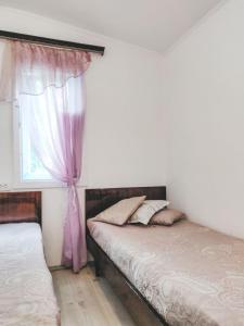 een slaapkamer met 2 bedden en een raam bij ДіВо in Bohuslav