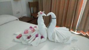 two swans made out of towels on a bed at Hostal S'Algaret in Fornells
